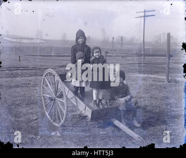 Antike 1900 Foto, vier Kinder in einem alten Bauernhof-Wagen. Ort unbekannt, möglicherweise in Michigan, USA. QUELLE: ORIGINAL GLAS NEGATIV. Stockfoto