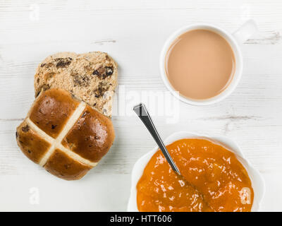 Geröstete Hot Cross Bun mit Tee und Aprikosenmarmelade Stockfoto