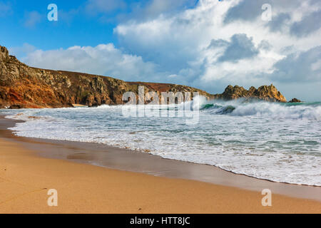 Blick auf Logan Rock von Porthcurno Strand. 28. Februar 2017. Stürmischen Wolken vorbei. Mit schönen Winter Sonnenlicht und einer Flut. © Stockfoto