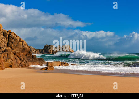 Blick auf Logan Rock von Porthcurno Strand. 28. Februar 2017. Stürmischen Wolken vorbei. Mit schönen Winter Sonnenlicht und einer Flut. © Stockfoto