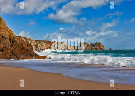 Blick auf Logan Rock von Porthcurno Strand. 28. Februar 2017. Stürmischen Wolken vorbei. Mit schönen Winter Sonnenlicht und einer Flut. © Stockfoto