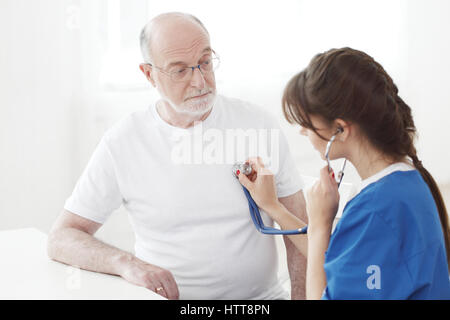 Arzt untersuchen Herzschlag senior männlichen Patienten Stockfoto