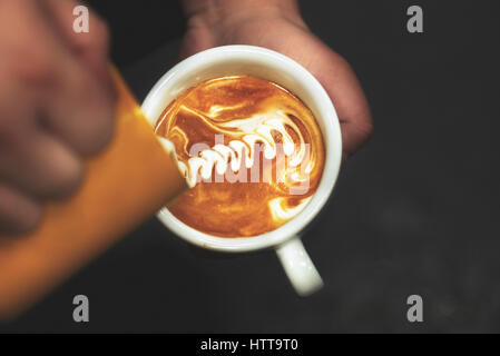 Tasse Kaffee. Latte Art Barista Focus in Milch und Kaffee gemacht. Vintage Farbe Stockfoto