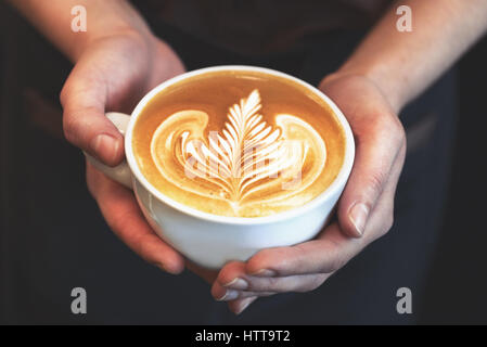 Tasse Kaffee. Latte Art Barista Focus in Milch und Kaffee gemacht. Vintage Farbe Stockfoto