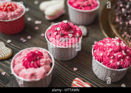 Rosa Cupcakes auf hölzernen Tisch. Stockfoto