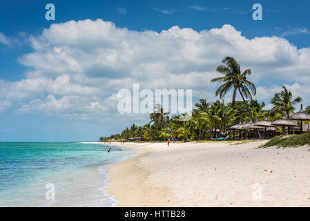 Le Morne, Mauritius - 11. Dezember 2015: Menschen sind am tropischen Strand mit Kokospalmen bewachsen, einer der schönsten Strände auf Mauritius entspannend. Stockfoto