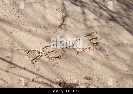 Das Wort Frieden im Sand am Strand Stockfoto