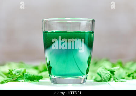 Das grüne Chlorophyll trinken aus Glas mit Wasser auf weißen Tisch mit grüner Minze Stockfoto