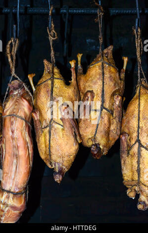 Der Prozess der geräuchertem Fleisch (Geflügel, Ente, Kaninchen) zu Hause. Die Karkasse, ausgesetzt in der Räucherkammer. Traditionelle Art des Kochens Fleisch in Europa. Stockfoto