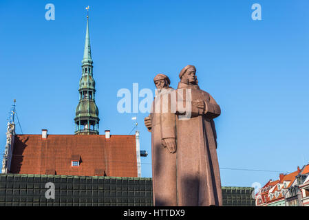 Denkmal von der lettischen schützen auf die Altstadt von Riga, Hauptstadt der Republik Lettland. Saint Peter Kirchturm im Hintergrund Stockfoto