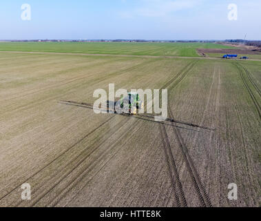 Traktor mit aufklappbaren Sprühen von Pestiziden. Düngung mit einem Traktor, in Form eines Aerosols auf dem Gebiet der Winterweizen Stockfoto