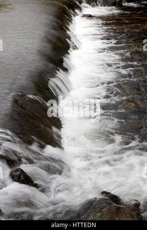 Schnell fließenden Gebirgsbach fließt über Felsen Stockfoto