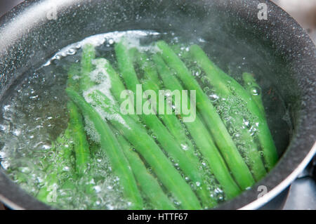 Frische grüne Bohnen kochen im Wasser Stockfoto