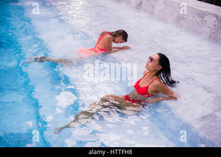 Junge Frauen entspannen am Pool Stockfoto