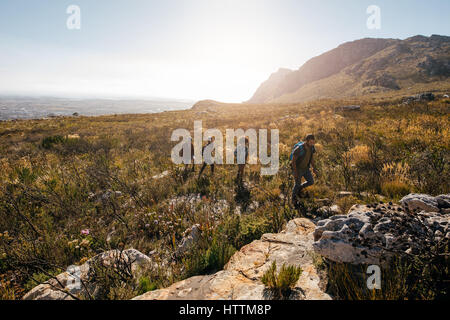 Gruppe von Freunden im extremen Gelände in Landschaft wandern. Junge Menschen im Land Fuß an einem Sommertag. Stockfoto