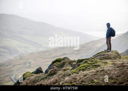 Ein Wanderer blickt auf Kirkstone Pass von der Seite der roten Geröllhalden in Cumbria. UK Stockfoto