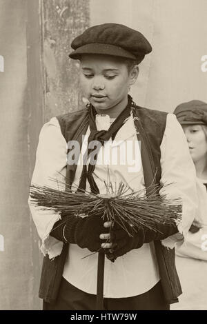 Viktorianische Kind chimneysweep, Schornsteinfeger, Singen im Victorian Weihnachtsfest in Portsmouth, Hampshire, England Großbritannien im November Stockfoto