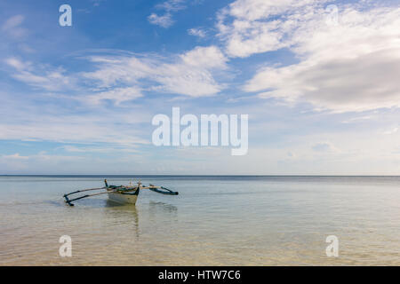 Traditionelle Filipino Fischerboot mit Möwen auf die Ausleger in einem ruhigen Meer schweben. Stockfoto