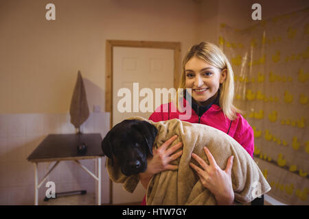 Frau Holding Hund in Badetuch Stockfoto