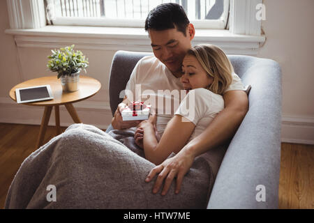 Mann Überraschungs-Geschenk für seine Frau auf sofa Stockfoto