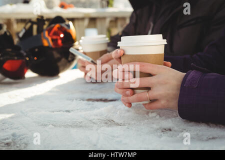 Paar mit Kaffeetasse mit Handy Stockfoto