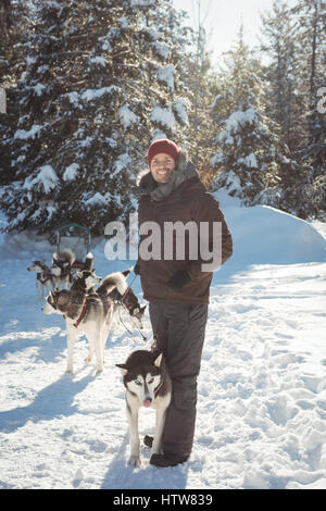 Mann, stehend mit Siberian Husky-Hunde Stockfoto