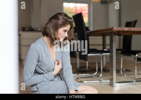 Junge Frau am Boden im Speisesaal Stockfoto