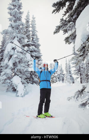 Skifahrer mit Ski auf Schneelandschaft stehend Stockfoto