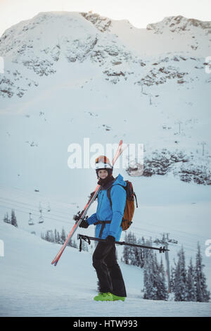 Skifahrer mit Ski auf Schneelandschaft stehend Stockfoto