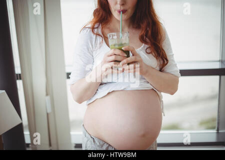 Schwangere Frau trinken Saft Stockfoto