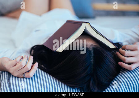 Weibliche jugendlich Eingeschlafen beim Lesen das Buch - Buch oben auf ihr Gesicht Stockfoto