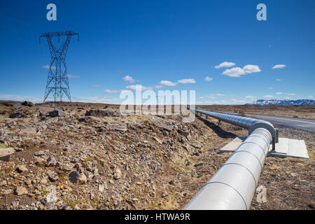 Elektrische Pol und geothermische Heißwasserrohr aus geothermischen Kraftwerk Nesjavellir nahe Straße 435 in Island Stockfoto