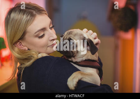 Frau, die einen Mops Welpen Stockfoto