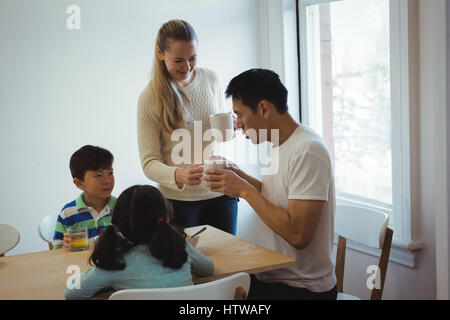 Frau serviert Kaffee, Mann Stockfoto