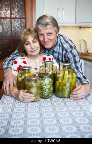 Glücklich Rentner mit hausgemachten Zubereitungen und Gurken in der Küche sitzen Stockfoto