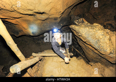 Vang Vieng, Laos - 15. Januar 2012: Junge mit einer Taschenlampe in Tham Jang (Chang Höhle) in Vang Vieng auf Laos Stockfoto