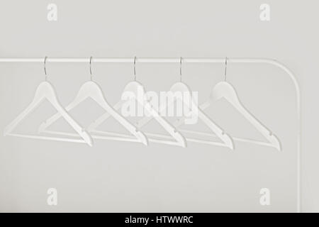 Schwarz-weiß-Foto mit der Unschärfe. Weiße Reihe von Kleiderbügeln auf dem Gestell. Selektiven Fokus. Stockfoto