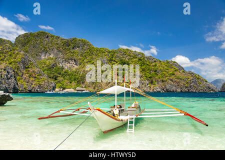 Traditionelle Banca Boot in klarem Wasser Payong Payong Beach, Miniloc Island in der Nähe von El Nido, Palawan, Philippinen Stockfoto