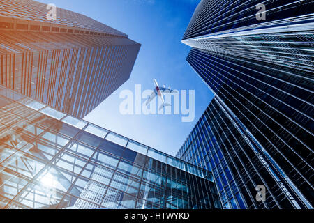 Flugzeug fliegen über Geschäft Wolkenkratzern. Stockfoto
