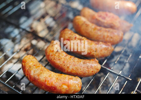 Würstchen braten auf dem Grill Rost beim Picknick Stockfoto