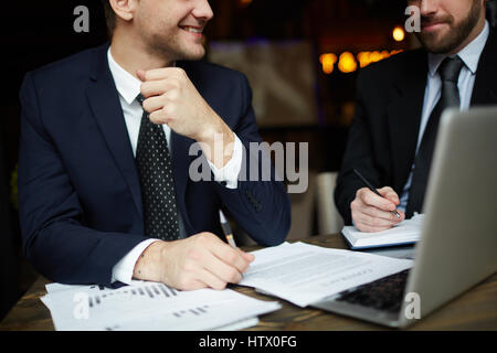 Closeup Portrait zweier unkenntlich erfolgreiche Geschäftspartner tragen schwarze formelle Anzüge Einkommensstatistik Prüfung und Unterzeichnung Vertrag Papiere Stockfoto