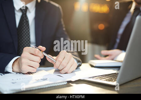 Closeup Portrait zweier unkenntlich erfolgreiche Geschäftspartner tragen schwarze formelle Anzüge Statistiken Dokumente überprüfen und diskutieren-Deal bei t Stockfoto