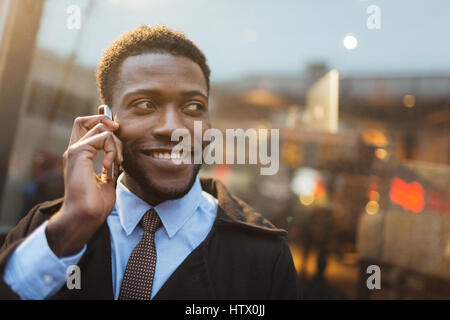 Afrikanisch-amerikanischer Mann mit toothy Lächeln am Telefon sprechen Stockfoto
