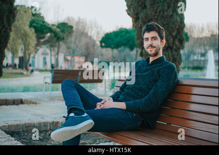 junge mexikanische Mann sitzt in einer Bank in einem park Stockfoto