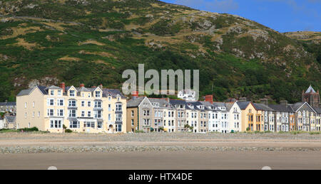 Häuser und Hotels entlang der Strandpromenade mit Dinas Oleu im Hintergrund Barmouth, Gwynedd, Wales, Europa Stockfoto