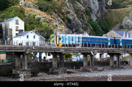 Ein Personenzug kreuzt am Hafen von Barmouth wie nähert sich der Station, Barmouth, Wales, Europa Stockfoto