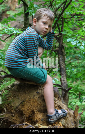 Kleiner Junge im gestreiften Pullover und Shorts im Sommer Waldpark Stockfoto