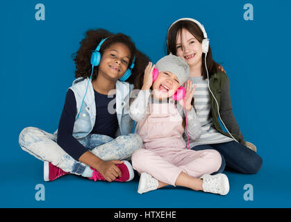 Gruppe von kleinen Mädchen Lächeln auf den Lippen tragen Studiokopfhörern und Winterkleidung Stockfoto