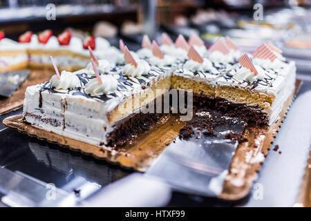 Scheiben einer geschichteten Schokolade und Vanille Kuchen mit Sahne, garniert mit gestreiften Quadrat Stockfoto