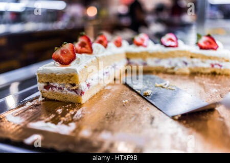 Scheiben von einer geschichteten Vanille-Kuchen mit Sahne, garniert mit Erdbeeren Stockfoto